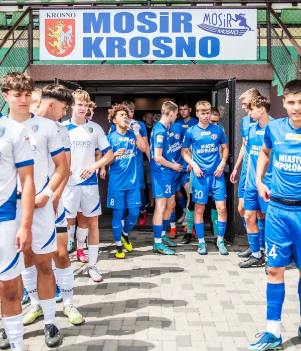 Młody zespół wychodzący na stadion. Na górze napisz MOSiR Krosno