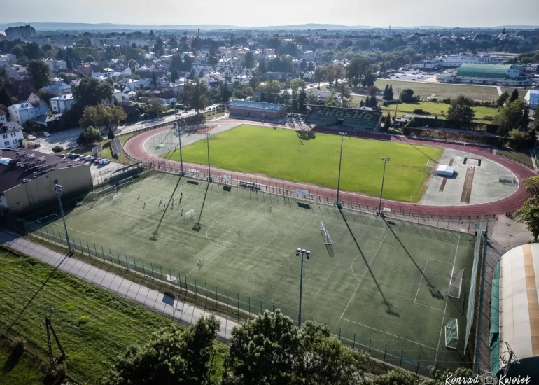 Boisko a w tle bieżnia i stadion lekkoatletyczny